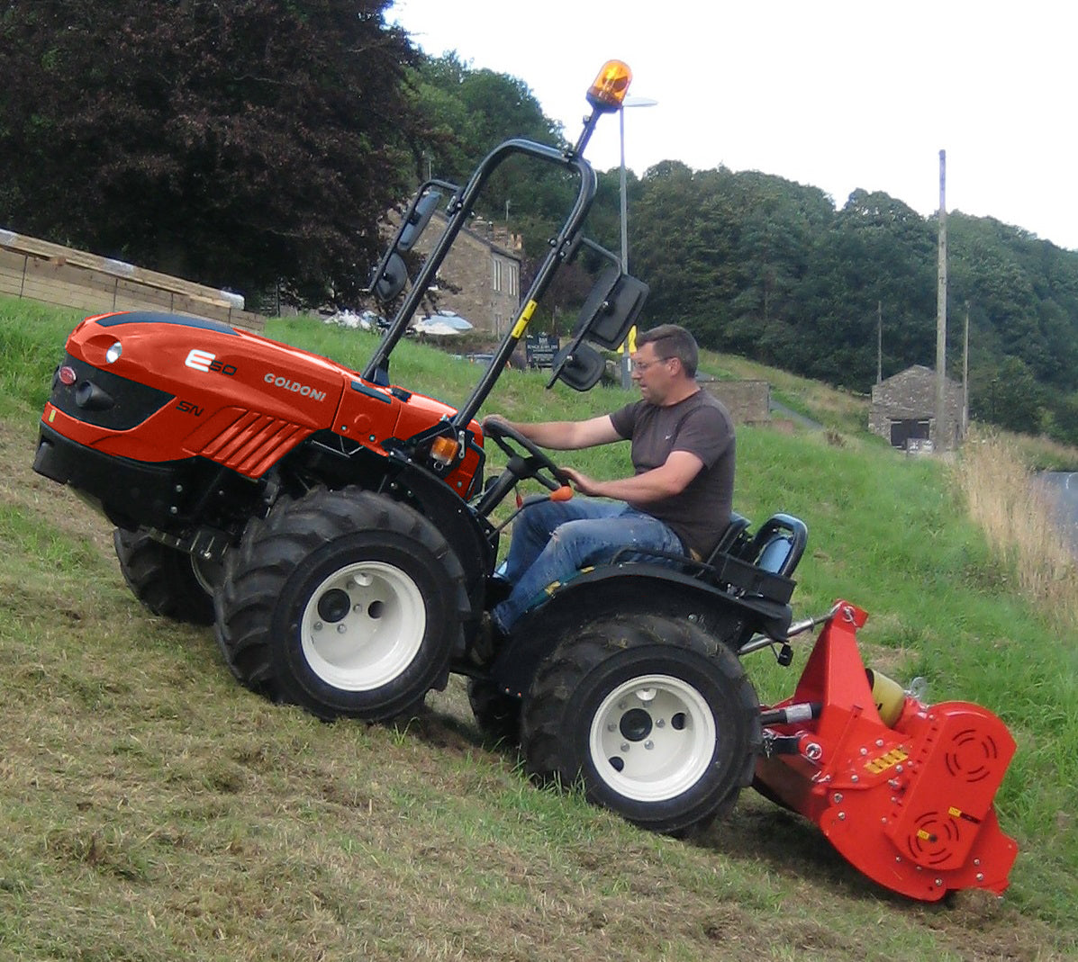 Goldoni E50 SN, articulated tractor with flail mower on steep slope